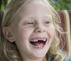 Happy young blond girl with missing front teeth